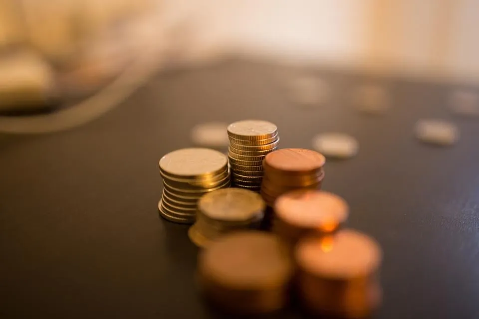 Stacks of copper and gold-colored coins on a dark table