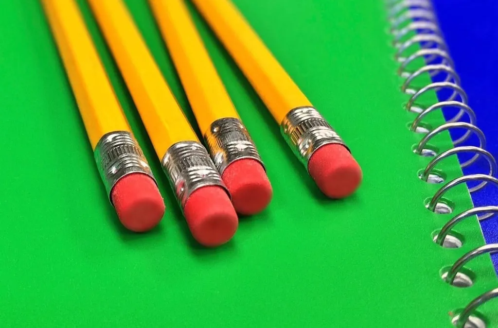 Yellow pencils with erasers resting on a green spiral notebook