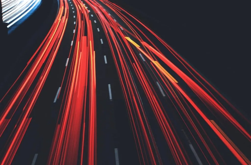 Long red light trails of cars on a multi-lane road at night
