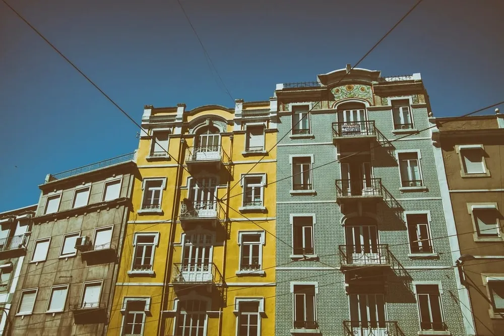 Tiled apartment buildings under a blue sky in a Lisbon street