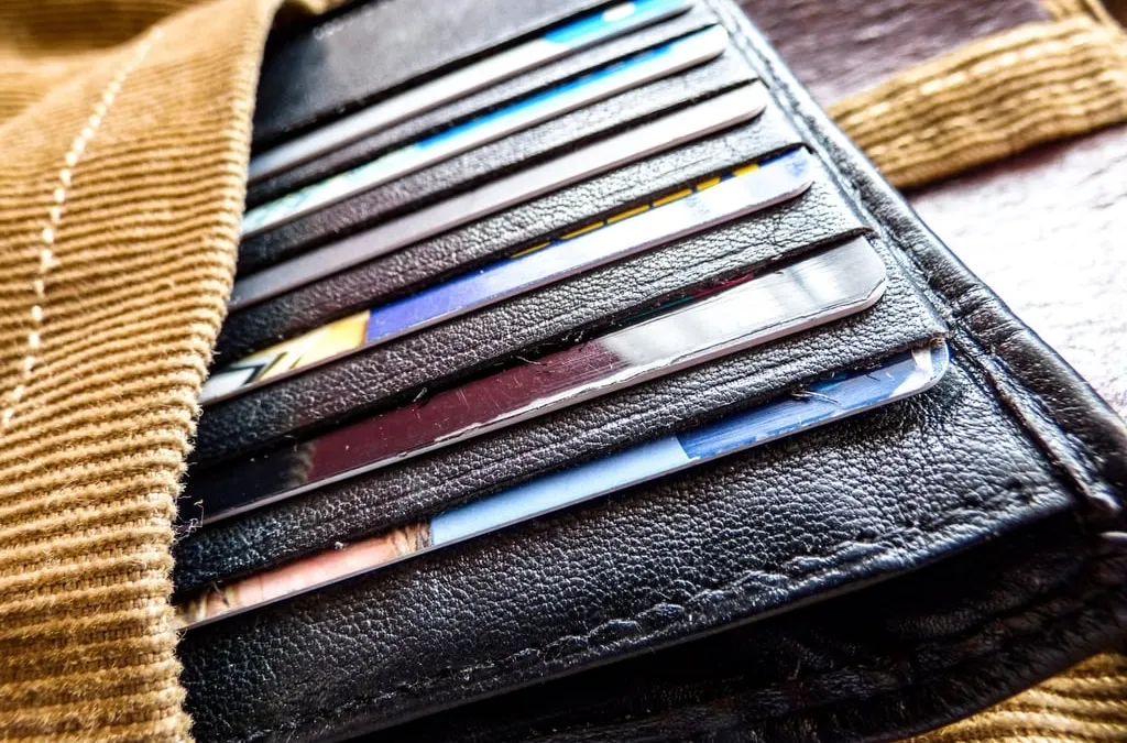 Several bank cards slotted into a black leather wallet