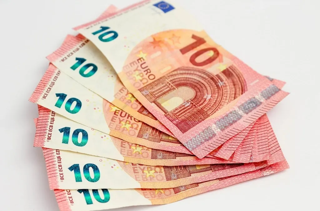 A fan of ten euro banknotes on a white surface
