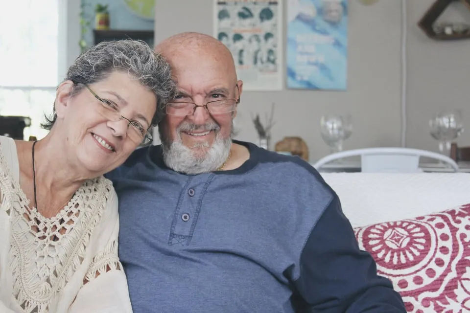 An older couple smiling together on a sofa